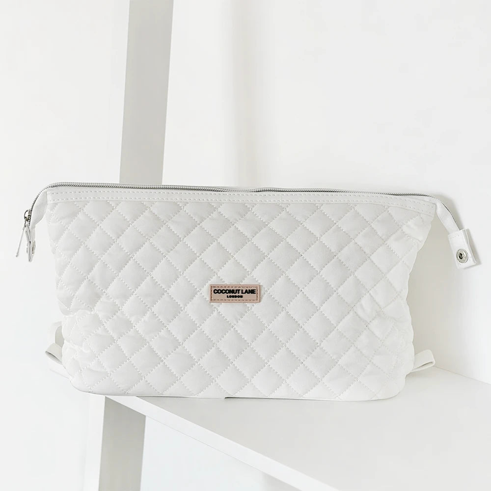 A beige, textured fabric pouch with a white zipper at the top and a small white label on the front that reads "COCONUT LANE". The background is a light, neutral color.