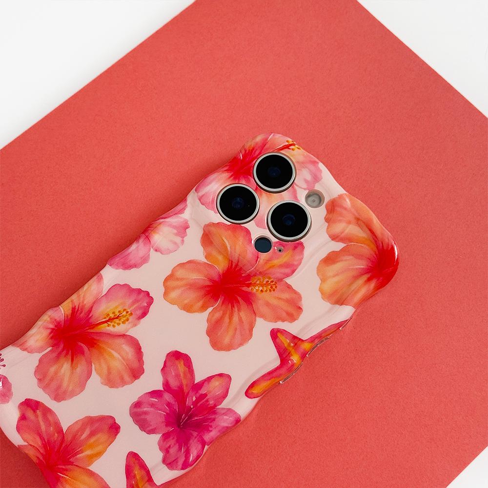 A smartphone with a pink case adorned with red hearts lies on brown paper. Surrounding items include heart-shaped cutouts, red rose petals, and a red ribbon printed with "all my love," set on a pink and red background.