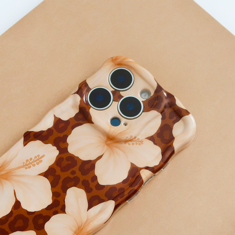 A white smartphone with a wavy, bubble-like case lies on a light surface surrounded by scattered pearls of various sizes. The phone's camera lenses are prominent at the top.