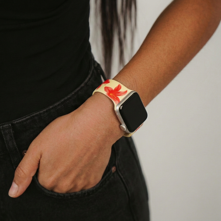 Apple Watch strap with red floral pattern on wrist, wearer’s hand in pocket.