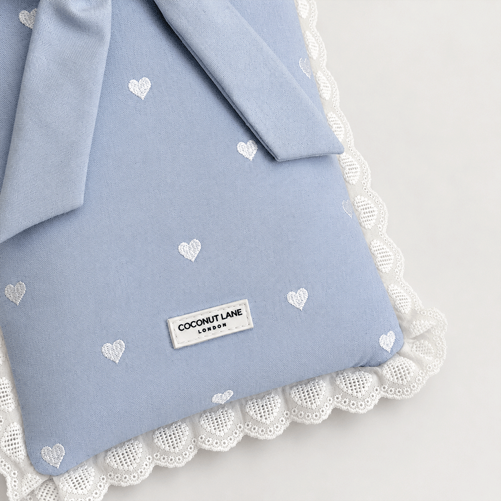 Blue fabric Book Sleeve with embroidered heart design, bow closure and white lace edging.