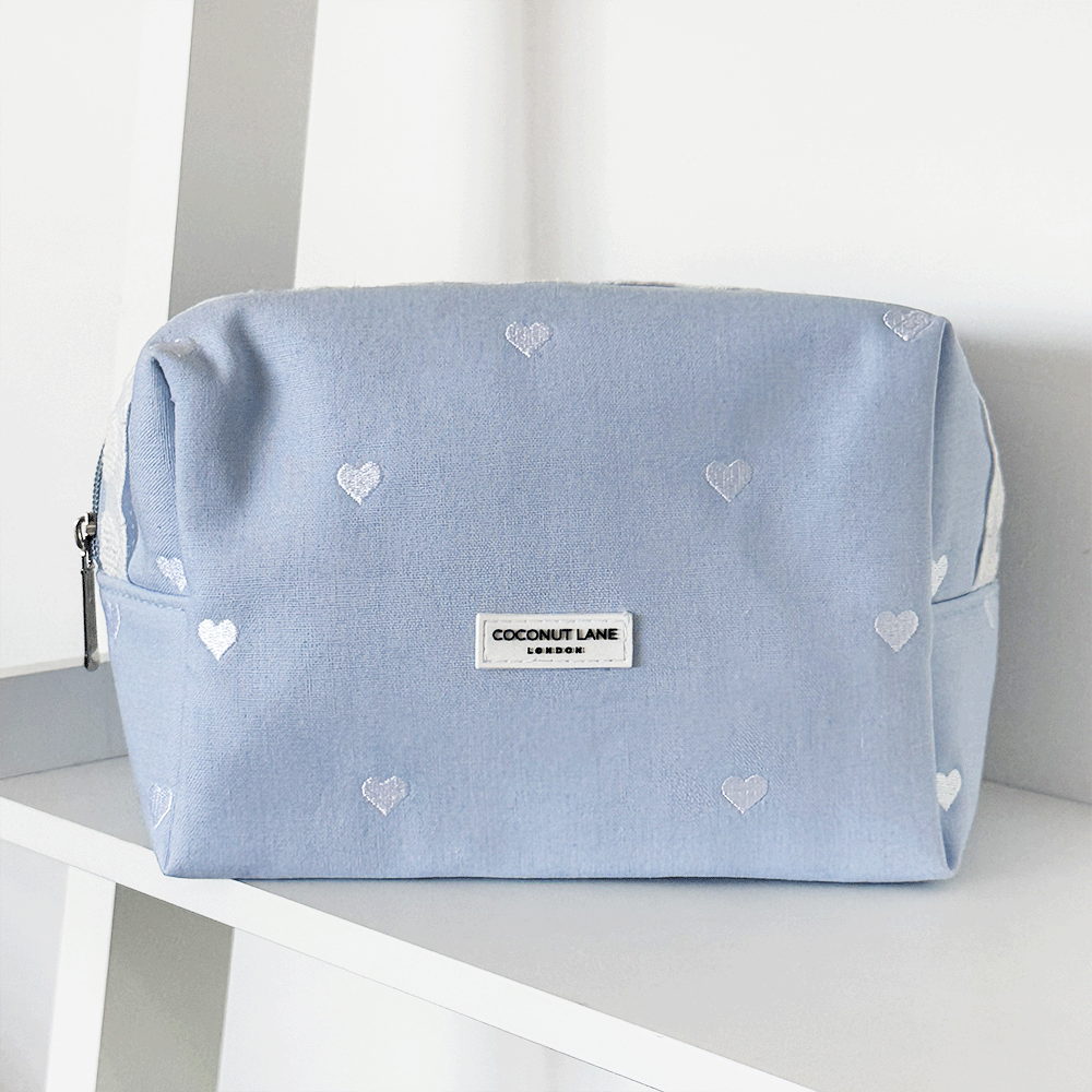 Blue fabric Makeup Bag with embroidered heart design and white lace trim.