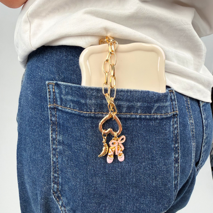 Croissant charm on phone strap with heart in jean pocket with phone case