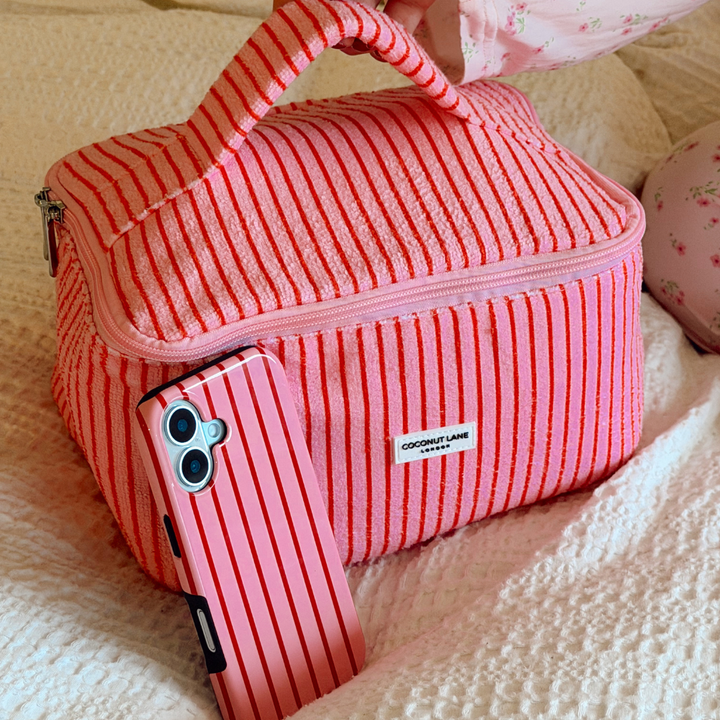 Cherry Stripes Tough Phone Case leaning on makeup bag