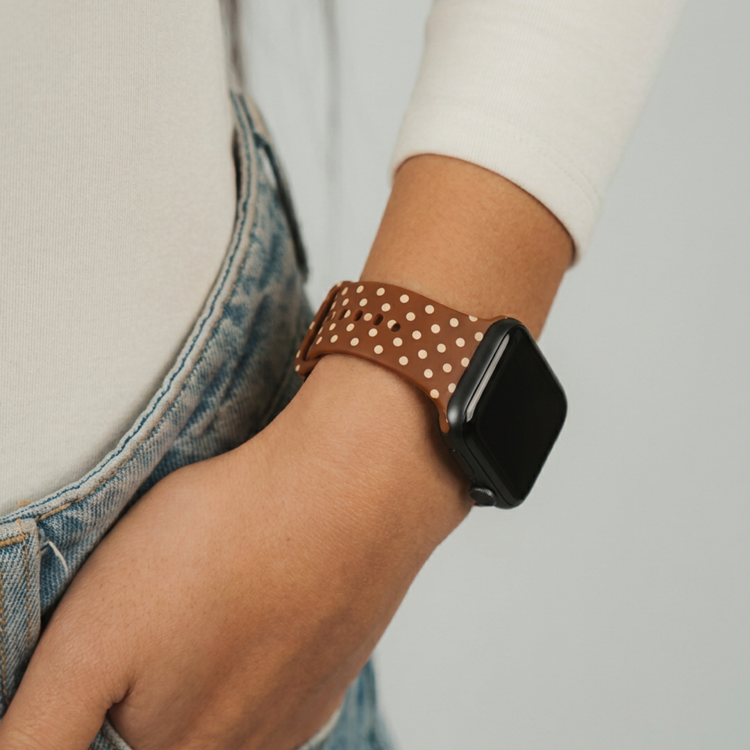 Woman wearing a coconut lane Brown silicone sport band with small cream polka dots.