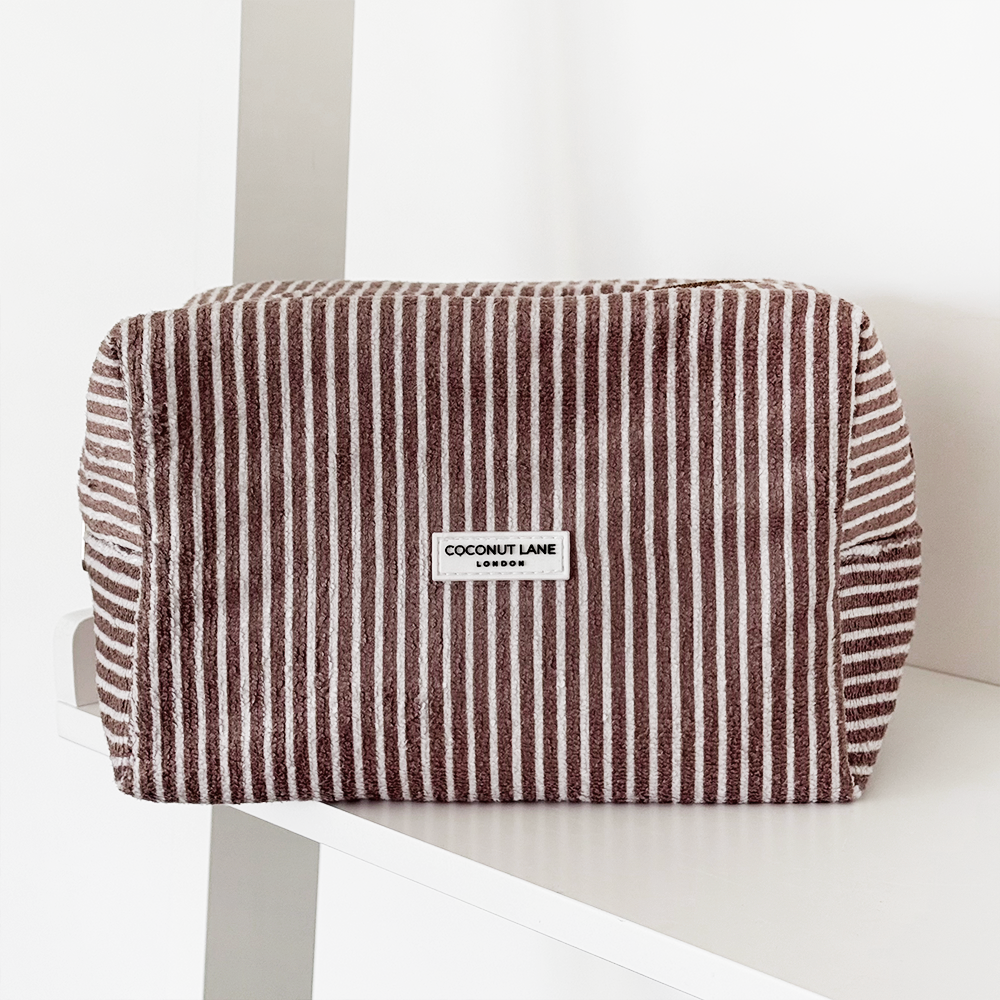 A minimalist desk with a lamp, plant, laptop, notebooks, and coffee beans.