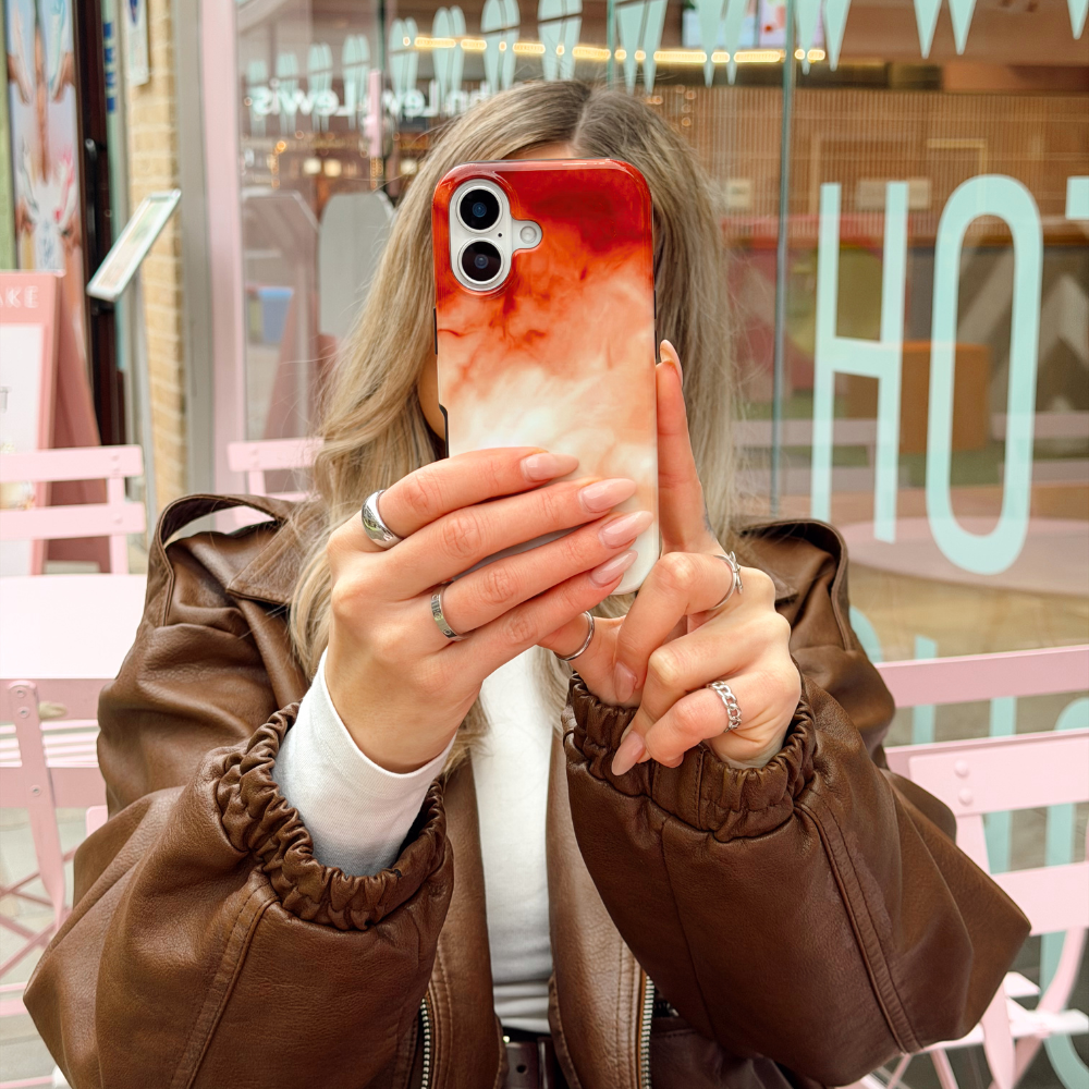 Girl in cafe holding the Iced Latte Tough Phone Case matching in brown and white