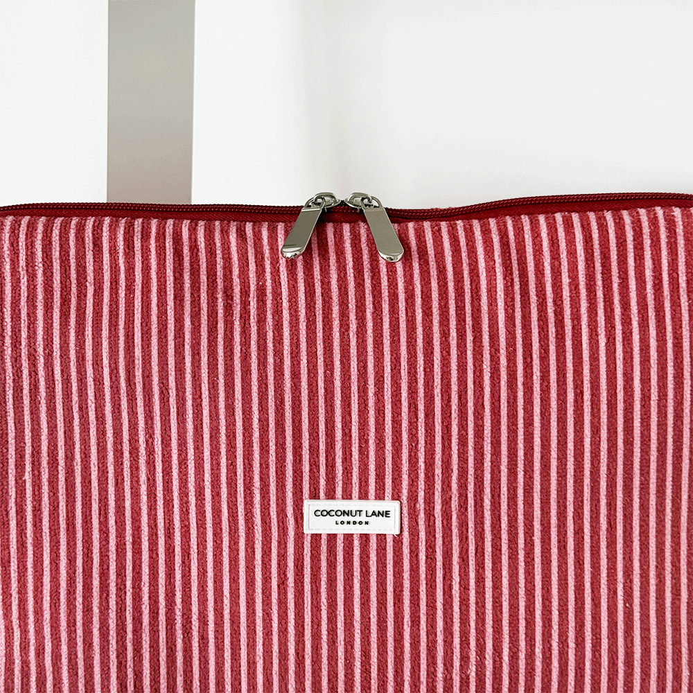 Red and white striped laptop sleeve with center label and zipper, displayed on a white background.