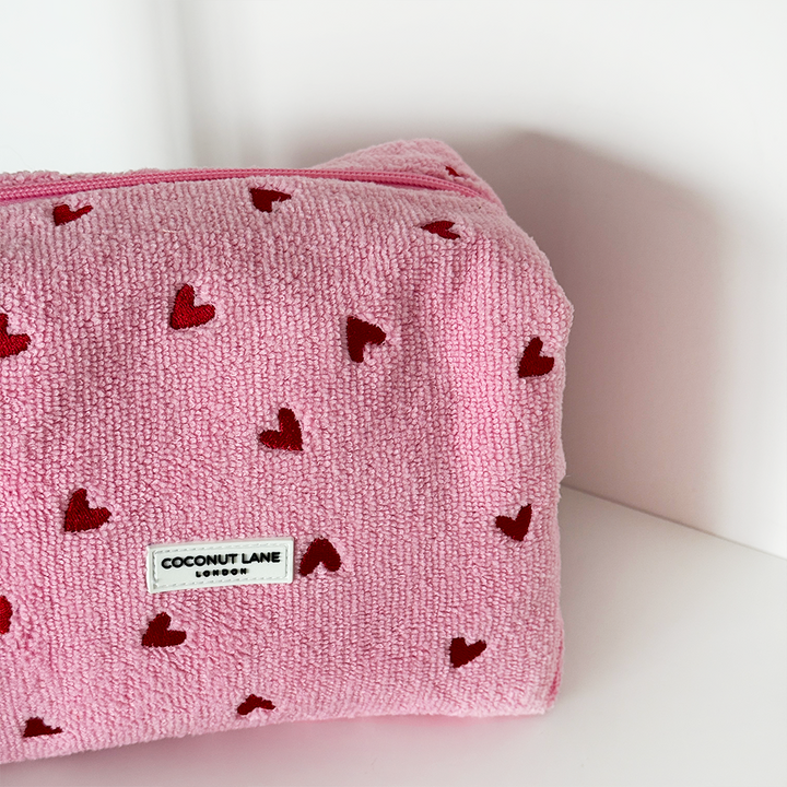 Pink pouch with red heart patterns and a Coconut Lane label on a white background