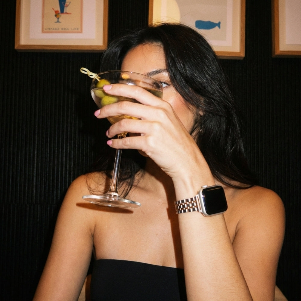 Woman in dark bar with martini and Watch Strap on wrist