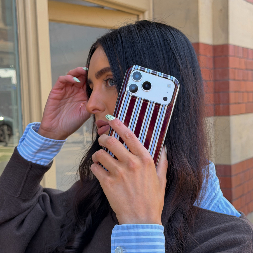 Girl holding phone with the Tough MagSafe Brown and BlueStripe Phone Case on her phone