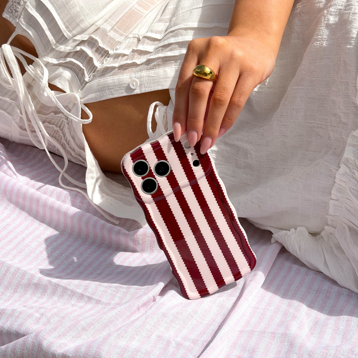 Girl on striped towel holding Wavy Blushberry Scallop Stripes Phone Case