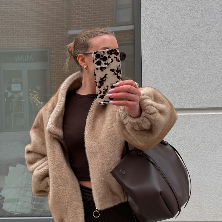 Girl taking selfie with wavy ivory tort phone case wearing brown