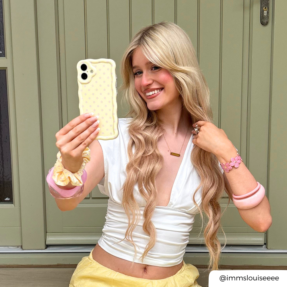 Girl in yellow taking selfie with Wavy Phone Case in Butter Blush with pink polka dots