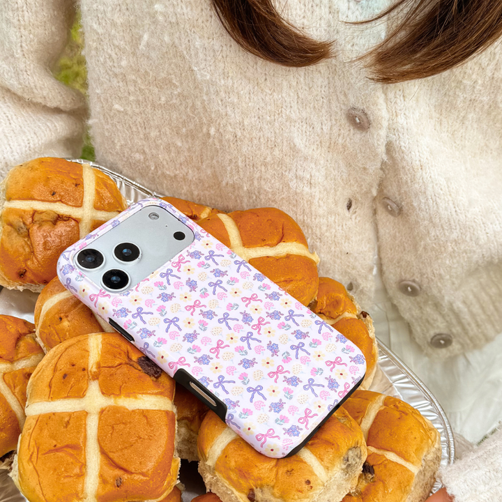 spring bows tough phone case laying on hot cross buns